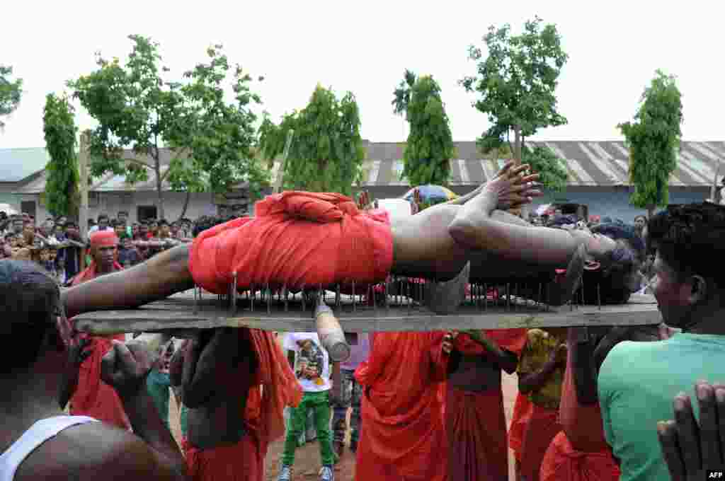 A Hindu devotee lies on a bed of nails as he is carried past spectators during the ritual of Shiva Gajan at Pratapgarh village in Agartala, the capital of northeastern state of Tripura. Devotees believe that by enduring the pain, Shiva, the Hindu god of destruction, will grant their prayers.