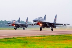 FILE - Two Chinese SU-30 fighter jets take off from an unspecified location to fly a patrol over the South China Sea, in this undated file photo released by China's Xinhua News Agency.
