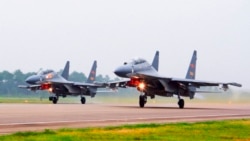 FILE - Two Chinese SU-30 fighter jets take off from an unspecified location to fly a patrol over the South China Sea, in this undated file photo released by China's Xinhua News Agency.