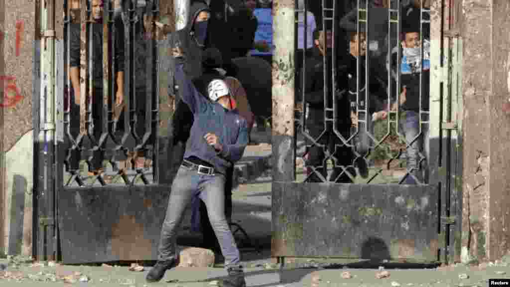 A student of Al-Azhar University, who is a supporter of the Muslim Brotherhood and deposed Egyptian President Mohamed Morsi, throws a stone during clashes with police in Cairo's Nasr City district, Jan. 8, 2014. 