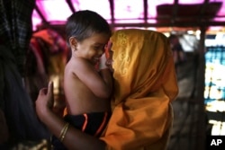 This 28-year-old mother of six, who did not want her name used, says she was raped by members of Myanmar's armed forces in late August. She caresses her daughter while being photographed in her tent in the Kutupalong refugee camp in Bangladesh, Nov. 22, 2017.