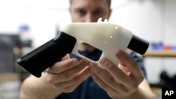 ທ້າວ ໂຄດີ ວີລສັນ ຢູ່ທີ່ ບໍລິສັດ Defense Distributed, ຖື ປືນ ພິມອອກມາໂດຍ ເຄື່ອງພິມ 3 ມິຕິ ຫຼື 3D-printed gun ທີ່ເອີ້ນວ່າ Liberator ຢູ່ທີ່ຮ້ານຂອງຜູ້ກ່ຽວ ໃນນະຄອນ ອອສຕິນ ໃນລັດເທັກຊັດ, ວັນທີ 1 ສິງຫາ 2018.