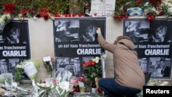 Người dân đặt hoa phía trước văn phòng báo Charlie Hebdo ở Paris, ngày 8/1/2015.