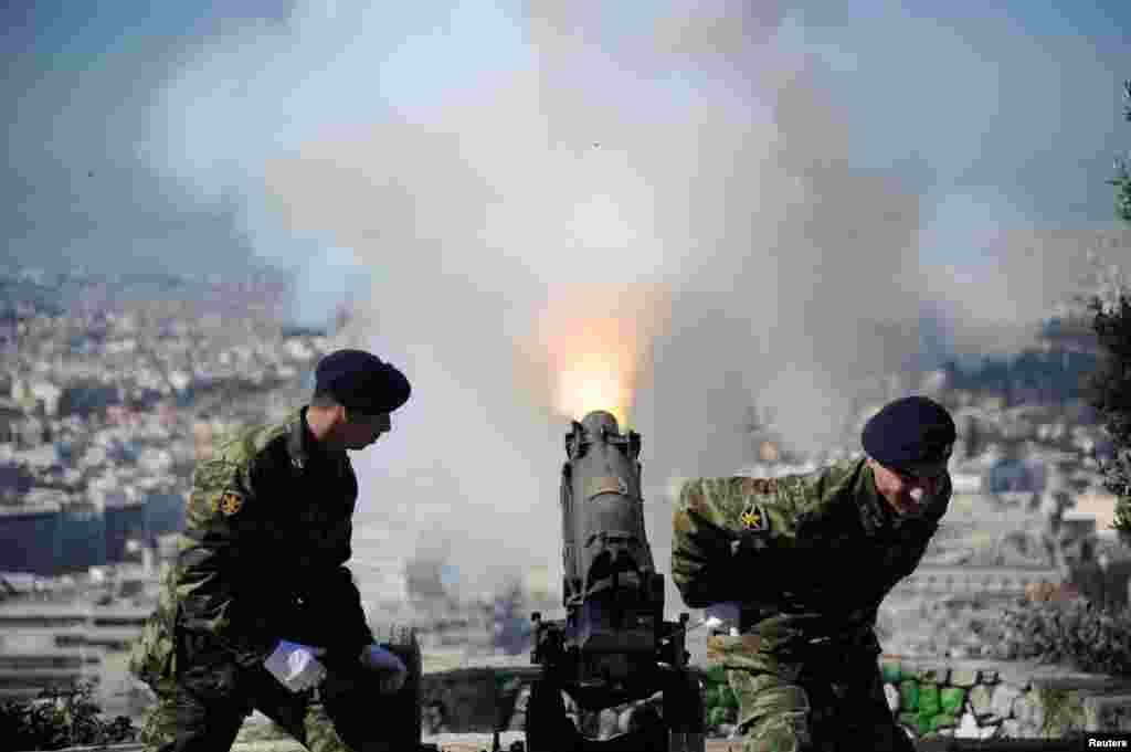 A canon fires from the hill of Lycabettus during Independence Day celebrations in Athens, Greece, March 25, 2017.