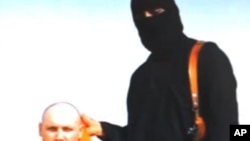 FILE - File still image from an undated video released by Islamic State militants on Aug. 19, 2014, purports to show journalist Steven Sotloff being held by the militant group.