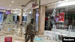 Un membre de l'armée inspecte les dégâts dans le centre commercial pillé de Jabulani pendant les troubles causés principalement par l'emprisonnement de l'ancien président Jacob Zuma, à Soweto, en Afrique du Sud, le 13 juillet 2021. REUTERS/Siphiwe Sibeko