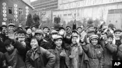 历史照片：中国青年在一家工厂外挥舞被称为“红宝书”的《毛泽东语录》。(1967年1月23日)