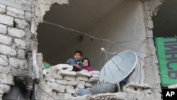 Des enfants dans une maison détruite pendant la guerre, à Alep en Syrie, le 11 février 2016.
