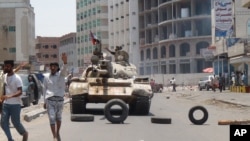 Milicianos leales al presidente de Yemen Abed Rabbo Mansour Hadi toman posiciones en una calle de Adén, Yemen, el jueves, 2 de abril, de 2015. 