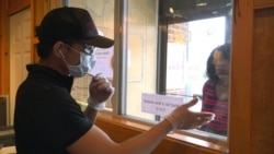 Nathapong Thongsuk, a staff of Thai House Restaurant talks to a customer through a to-go window at Thai House Restaurant in Gaithersburg, MD.,March 29, 2020