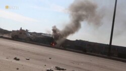 An armored vehicle rides next to a smoke as Syrian Democratic Forces affiliates clash with Islamic State militants outside a prison in Hasakah, Syria, Jan. 22, 2022, in this screen grab taken from a video.