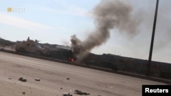 An armored vehicle rides next to a smoke as Syrian Democratic Forces affiliates clash with Islamic State militants outside a prison in Hasakah, Syria, Jan. 22, 2022, in this screen grab taken from a video.