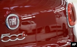 FILE - A reflection of a white Fiat 500 L cars in the red car in the new Fiat factory in Kragujevac, some 100 kilometers (70 miles) south of Belgrade, Serbia, Monday, April 16, 2012. (AP Photo/Darko Vojinovic)