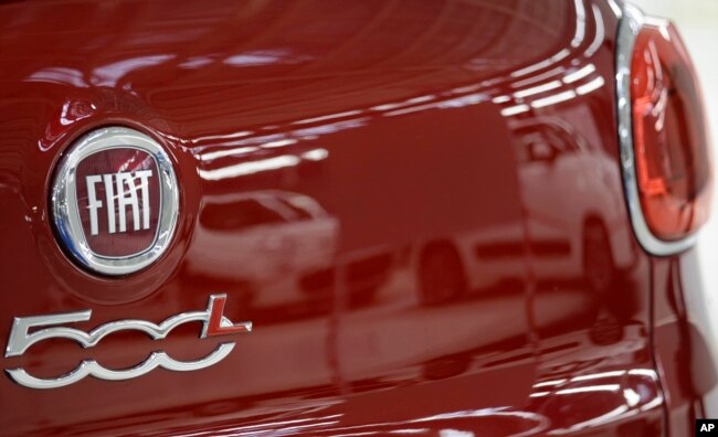 FILE - A reflection of a white Fiat 500 L cars in the red car in the new Fiat factory in Kragujevac, some 100 kilometers (70 miles) south of Belgrade, Serbia, Monday, April 16, 2012. (AP Photo/Darko Vojinovic)