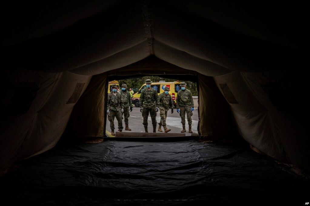 Soldados del ejército español montan una carpa para ser utilizadas por pacientes del hospital, durante el brote de coronavirus en Madrid, España. 