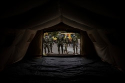 Spanish Army soldiers mount a tent to be used by hospital patients during the coronavirus outbreak in Madrid, Spain, Monday, March 30, 2020.