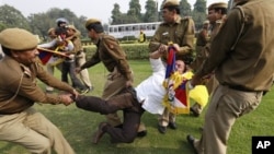 Indian policemen detain a Tibetan Youth Congress supporter as he protests outside the Chinese Embassy in New Delhi, India, November 12, 2012.
