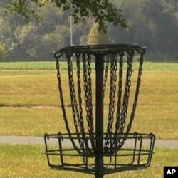 Instead of shooting for a hole on the green, disc golf players aim for a raised metal basket.