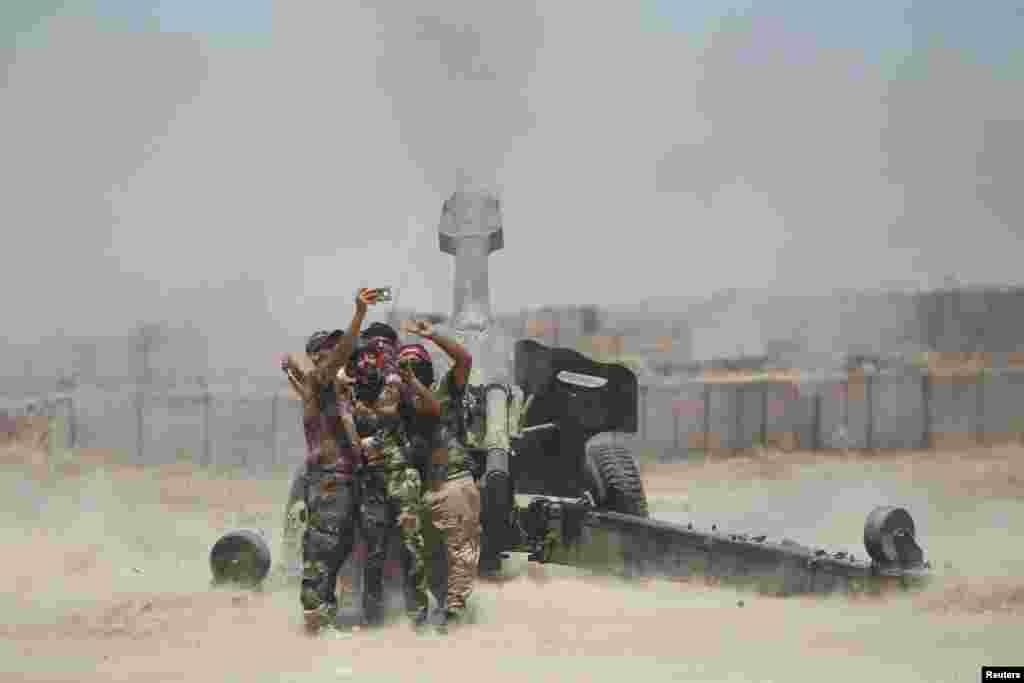 Shi&#39;ite fighters take a selfie while firing artillery towards Islamic State militants near Falluja, Iraq.