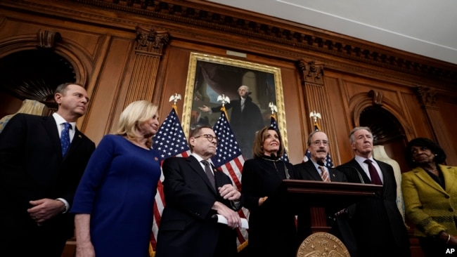 众议院议长佩洛西在众议院通过针对特朗普的两项弹劾条款后在国会山对媒体讲话，与她站在一起是众议院各委员会的主席。(2019年12月18日)