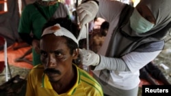 A migrant, who arrived in Indonesia by boat yesterday along with other Bangladeshi and Rohingya migrants, receives medical treatment in Kuala Langsa, in Indonesia's Aceh province, May 16, 2015. 