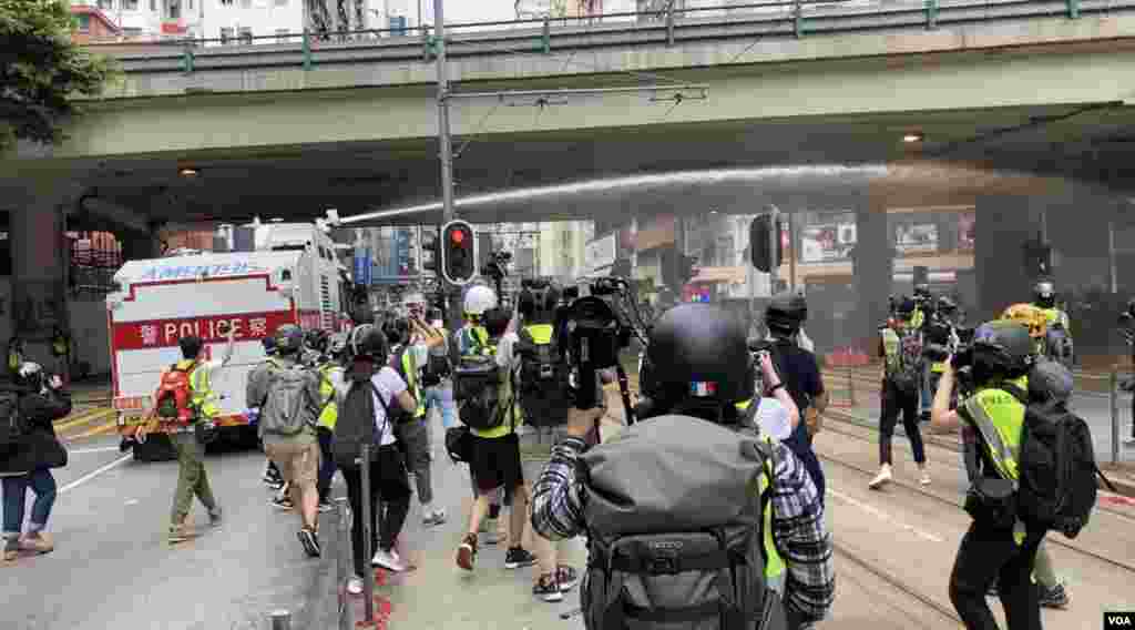 香港警方5月24日出動水炮車，多次在灣仔鵝頸橋噴射胡椒水驅散集結的人群。(美國之音湯惠芸拍攝)