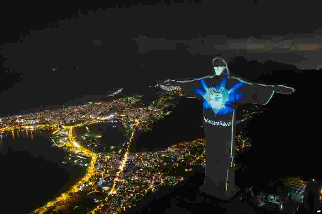 Rio&#39;s Christ the Redeemer statue is lit up as if wearing a protective mask amid the new coronavirus pandemic, in Rio de Janeiro, Brazil, Sunday, May 3, 2020. 