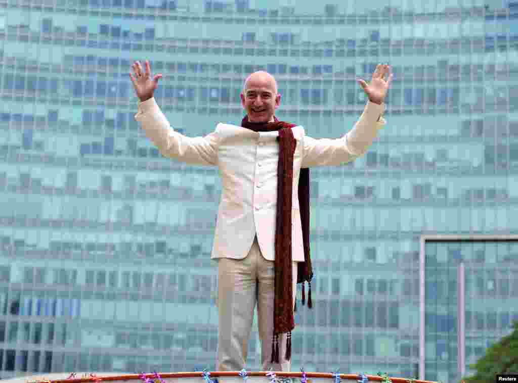 Jeff Bezos, founder and chief executive officer of Amazon, stands atop a supply truck during a photo opportunity at the premises of a shopping mall in the southern Indian city of Bangalore. 