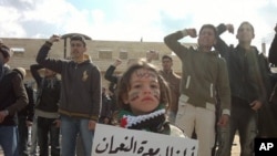 Demonstrators protest against Syria's President Bashar Al-Assad in Marat al-Numan near the northern province of Idlib. The bannr reads, "The children Marar Al-Numan, sacrifice our lives for you Bab Amro", March 2, 2012. 
