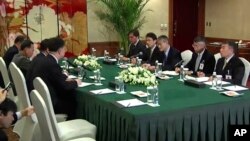 Video image shows Osamu Tasaka (3rd-R), director general of the International Department at the Japanese Red Cross, meeting with Ri Ho Rim (3rd-L), secretary general of North Korea's Red Cross Society, in Shenyang, China, March 3, 2014.