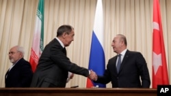 지난 20일 세르게이 라브로프 러시아 외무장관(가운데)과 메브류트 차부쇼울루 터키 외무장관이 모스크바에서 공동 기자회견을 가진 후 악수하고 있다.