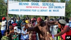 Crowds watch two dancers at an opposition rally in Ziguinchor, the regional capital of Senegal's southern Casamance province on Saturday, May 14