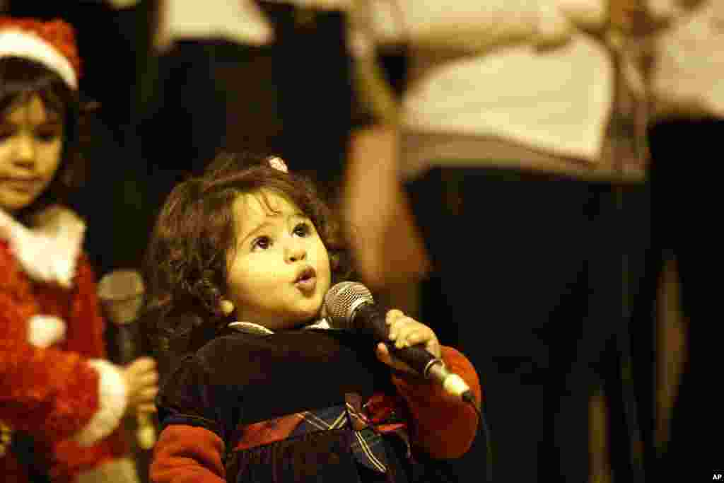 A young Egyptian Christian girl sings during New Year's Eve Mass at the Cave Cathedral or St. Sama'ans Church in the Moqattam district of Cairo, Egypt, Dec. 31, 2014.