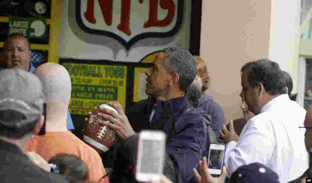 U.S. President Barack Obama, accompanied by New Jersey Governor Chris Christie, plays the &#39;Touch Down Fever&#39; game on the boardwalk, Point Pleasant, New Jersey, May 28, 2013.