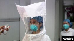 Medical staff test whether an Ebola protective suit is leak-proof at Shenzhen Third People's Hospital, in Shenzhen, Guangdong province, Oct. 22, 2014. 
