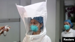 Medical staff test whether an Ebola protective suit is leak-proof at Shenzhen Third People's Hospital, in Shenzhen, Guangdong province, Oct. 22, 2014. 