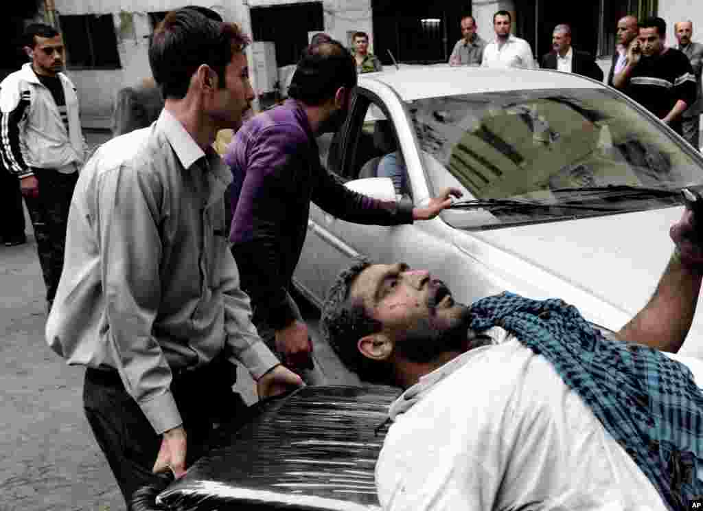 این عکس منتشر شده توسط خبرگزاری رسمی سوریه، سانا، مرد سوری را در حال کمک رسانی به يک زخمی پس از انفجار اتومبيل در دمشق نشان می دهد. ۵ نوامبر، ۲۰۱۲.