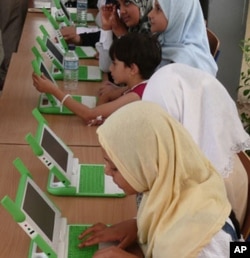 Gilrs in Najmi, Muthanna province, Iraq with OLPC computers.