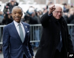 Democratic presidential candidate Sen. Bernie Sanders, I-Vt., right, accompanied by Rev. Al Sharpton, raises a fist as he arrives for a breakfast meeting at Sylvia's Restaurant, Feb. 10, 2016, in the Harlem neighborhood of New York.