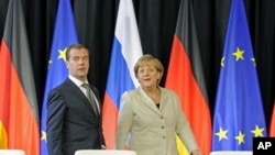 Russian President Dmitry Medvedev (L) and German Chancellor Angela Merkel arrive for a signing ceremony after a round of German-Russian consultations in Hanover, Germany, July 19, 2011