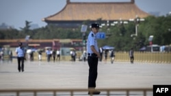 Police officers patrol and secure an area on Tiananmen Square in Beijing on June 3, 2019.