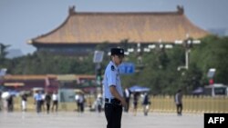 Police officers patrol and secure an area on Tiananmen Square in Beijing on June 3, 2019. 