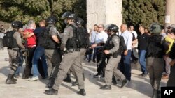 Palestinians and Israeli border police officers scuffle inside the Al-Aqsa Mosque compound, July 27, 2017. 