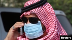 A man with mask speaks on his mobile phone in Jeddah, Saudi Arabia, May 29, 2014.