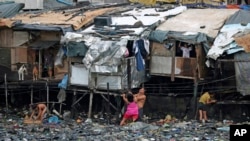 Residents strengthen their homes built on stilts as they brace for incoming Typhoon Rammasun, beside Manila's bay, Philippines on Tuesday, July 15, 2014. 