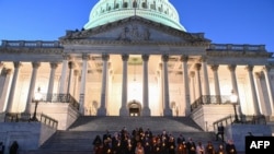 La presidenta de la Cámara de Representantes de Estados Unidos, Nancy Pelosi, el líder de la mayoría del Senado, Chuck Schumer y el líder republicano de la Cámara, Kevin McCarthy, sostienen velas eléctricas mientras participan en una vigilia en memoria de los muertos por COVID.