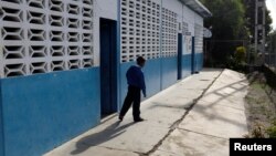 A kid walks past a classroom on the first day of school, in Caucagua, Venezuela, Sept. 17, 2018. 