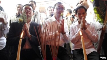 រូបឯកសារ៖ មេដឹកនាំគណបក្សសង្គ្រោះជាតិ និងលោក ជា មុន្នី ប្រធានសហជីពសេរីកម្មករកម្ពុជា អុជធូបបួងសួងនៅកន្លែងដែលលោក ជា វិជ្ជាត្រូវឃាតករបាញ់សម្លាប់កាលពីឆ្នាំ២០០៤។ (ហេង រស្មី/ VOA Khmer)