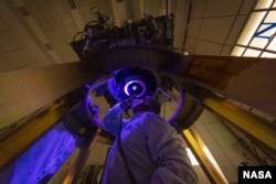 Los miembros del equipo de DART instalan e inspeccionan el único instrumento de la nave espacial DART, la Cámara de reconocimiento Didymos y la Cámara de navegación de asteroides (DRACO), en la nave espacial en junio de 2021 (Crédito de la imagen: NASA/Johns Hopkins APL/Ed Whitman)