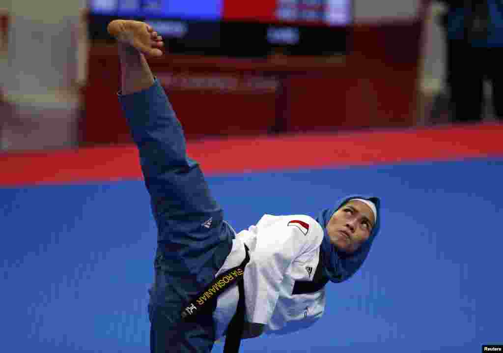 Atlet taekwondo putri Indonesia, Defia Rosmaniar saat beraksi di ajang Asian Games, Minggu (19/8). (REUTERS/Willy Kurniawan)